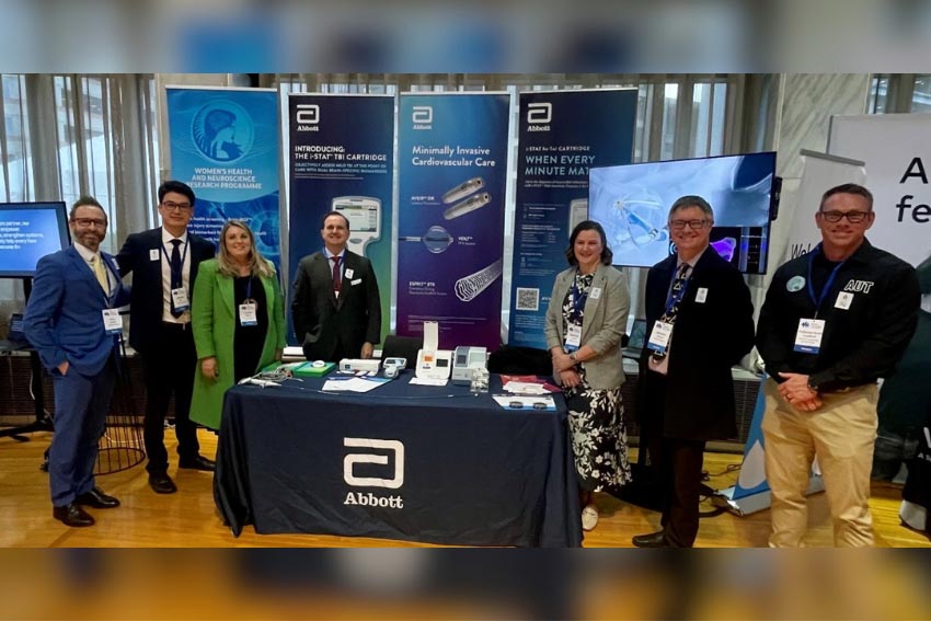 Abbott team standing in front of Abbott sign.