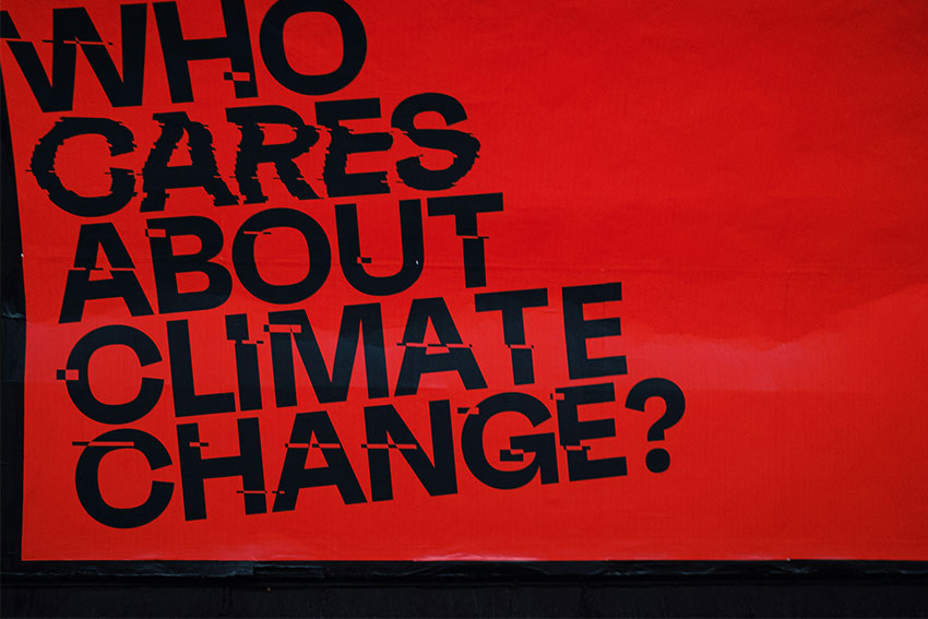 A red sign that says 'who cares about climate change?'