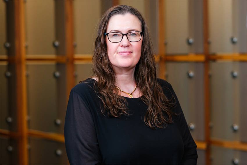 Lecturer against white wall. 