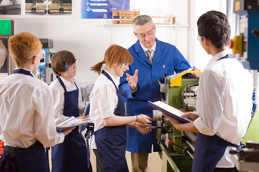 Stock image of high school students being taught in a workshop.